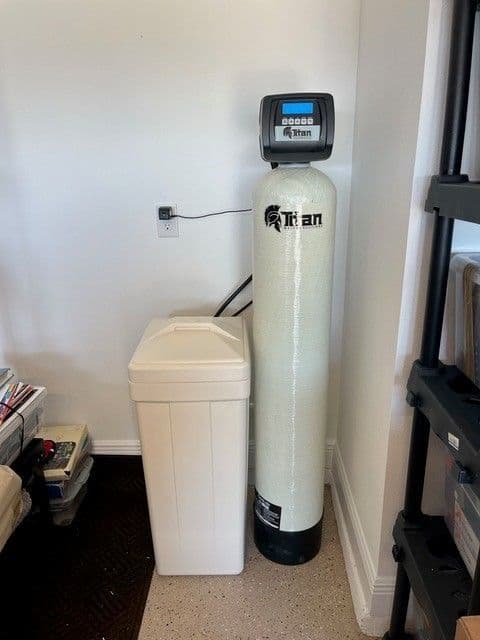 Titan whole-home water treatment system with white tank and salt container.