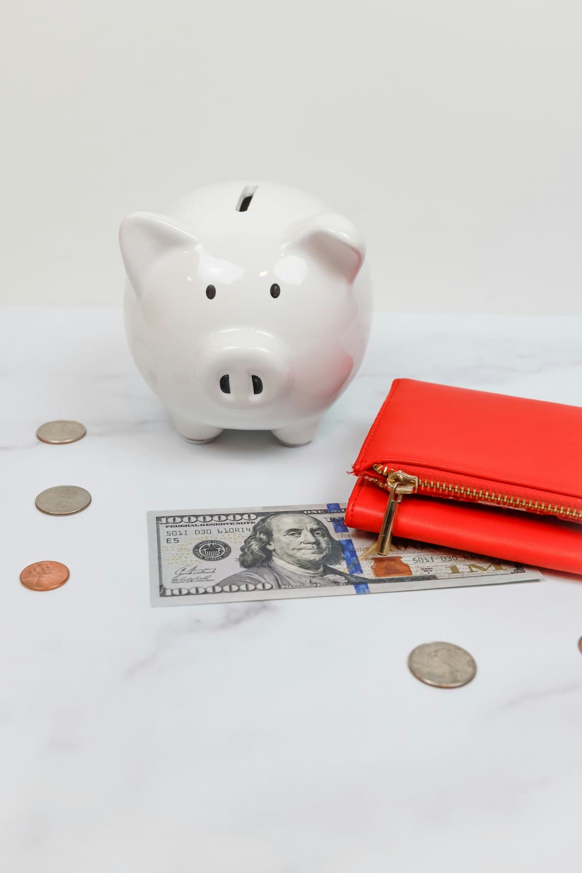 A piggy bank next to cash and coins