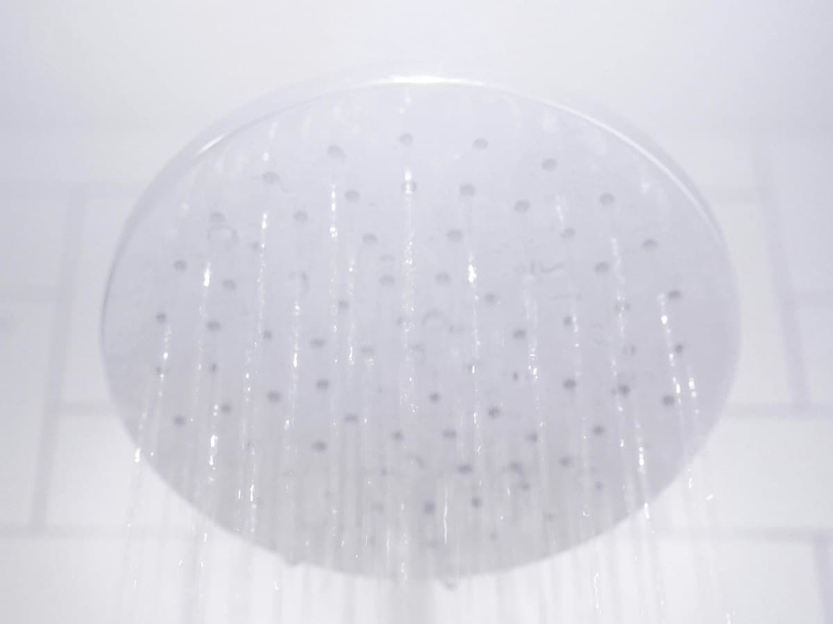 A modern rainfall showerhead with clean water flowing from it